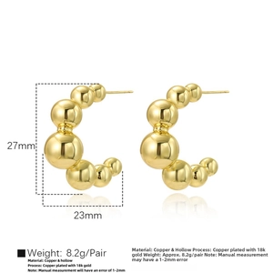 Detail view of large hollow 18k gold plated ball earrings with 27mm height dimensions