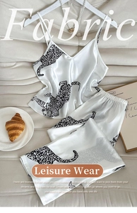 Detail view of Leopard print satin camisole pajama set with elegant lifestyle props