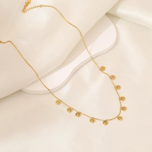 Golden tree of life pendant necklace displayed on premium white silk background
