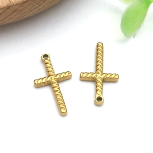 Detailed view of twisted golden cross charms with ring holes for DIY jewelry making