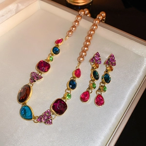 Detail of vintage necklace set with pearls and multicolored gems in a beige gift box