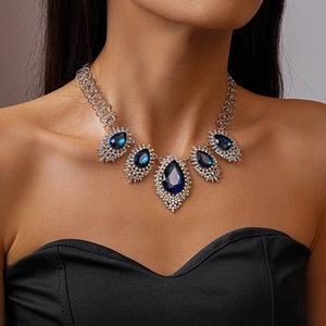 Close-up of vintage teardrop blue crystal pendant with silver setting on neck