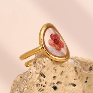 Détail macro d'une bague plaquée or 18 carats avec véritable fleur séchée rose et résine