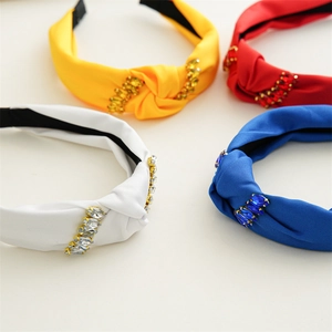 Detailed view of four knotted fabric headbands in red, blue, white, and yellow with rhinestones