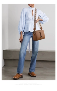 Brown lychee texture leather crossbody bag featuring a woven geometric shoulder strap