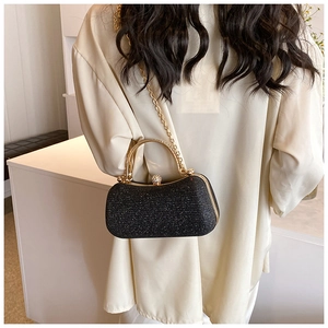 Detail of elegant black sequin evening clutch with golden handle and rhinestone clasp