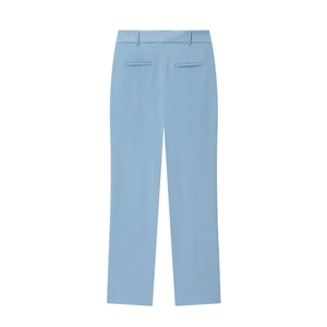 Dettaglio del retro di pantaloni a zampa azzurri con cuciture precise e trama del tessuto