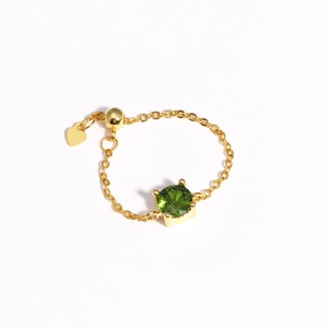 Adjustable gold chain ring with green zircon crystal and heart charm detail