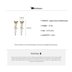 Detail view of long butterfly earrings with zircon, pearls and measurements label