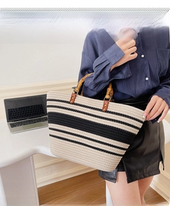 Close-up of woven tote bag with black and white stripes and bamboo top handle