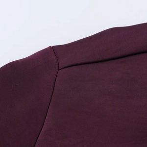Macro detail of dark purple silk satin fabric with fine shoulder seam craftsmanship