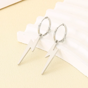 Close-up of polished silver lightning bolt drop earrings on a wavy white stand
