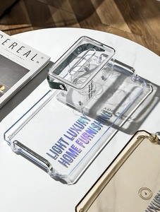 Close-up of luxury transparent acrylic storage trays with handles on marble surface