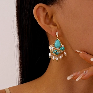 Detail view of vintage flower earrings with turquoise stone and pearl tassels on a model