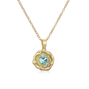 Detail of gold plated necklace with blue heart gemstone and wavy geometric pendant