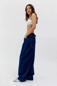 Vue latérale d'un jean vintage bleu foncé à jambes larges avec un drapé fluide