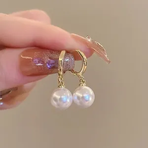 Elegant gold hoop earrings with lustrous white pearls for a classic French style aesthetic