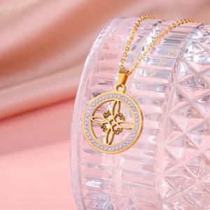 Detail der goldenen Hexenknoten-Halskette mit Strass auf einem diamantgeschliffenen Glas