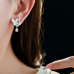 Détail de la boucle d'oreille papillon avec zircon violet et goutte sur le modèle