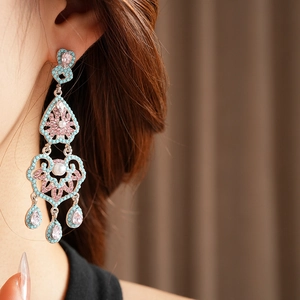 Gros plan de boucles d'oreilles vintage avec pierres roses et perles nacrées