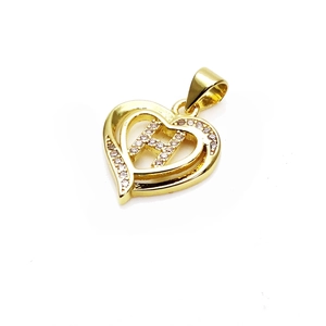 Macro shot of gold heart pendant with letter H and sparkling cubic zirconia stones