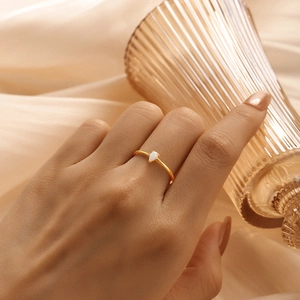 Detailed macro of gold S925 silver ring featuring a pear-shaped white opal stone