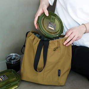 Waterproof drawstring canvas lunch bag in mustard yellow with metal snap pocket and handle