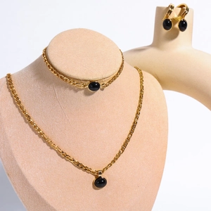 Detailed set of 14K gold Figaro chains with black natural stones on jewelry mannequin