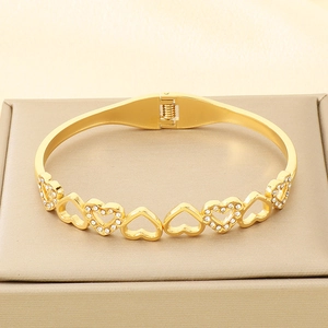 Detail of gold hollow heart bracelet with shimmering crystals on luxury display box