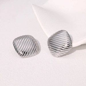 Close-up of silver geometric square earrings featuring detailed vertical textured stripes