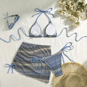 Vue à plat d'un ensemble bikini trois pièces à vagues bleues avec paréo et chapeau de plage