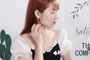 Close-up of elegant red crystal glass bead earrings with silver hooks on a model
