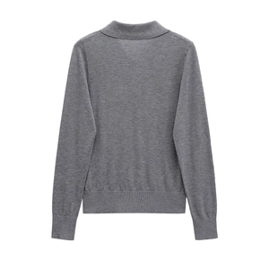 Detail view of the ribbed hem and smooth knit texture on the back of a grey polo sweater