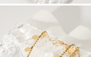 Detail of 18K gold plated beaded anklet with radial textured petal pendants on glass