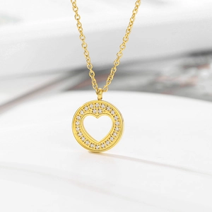 Macro shot of 18k gold plated heart pendant with pavé crystals on a minimalist chain