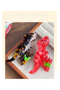 Detail view of cartoon dinosaur hair claw clips in tortoiseshell and vibrant red finish