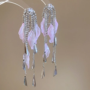Detail of long tassel earrings with pink petals, silver chains and sparkling rhinestones
