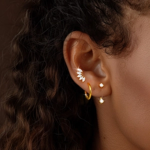 Close-up of model wearing gold S925 sterling silver hoop earrings with cubic zirconia