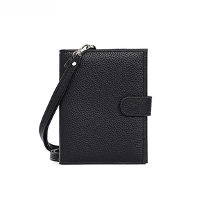 Close-up of black lychee grain leather passport holder with silver metal hardware and strap