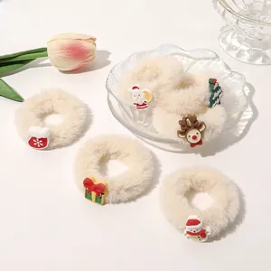 Close-up of five white plush Christmas scrunchies with Santa and deer ornaments