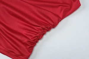 Dettaglio del tessuto a maglia rossa con eleganti arricciature e trama a coste di tendenza