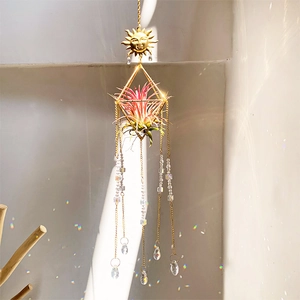 Detail of golden sun prism crystal catcher casting rainbow shadows on a wall