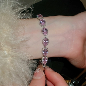 Close-up of pink pear-shaped zircon stones and silver beaded details on a woman wrist