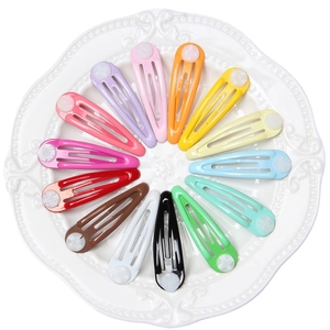 Classic colorful snap hair clips in 14 candy colors arranged on a white ceramic plate