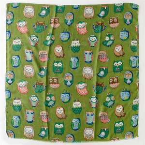 Detail shot of colorful cartoon owl patterns on green cotton linen feel scarf with fringes