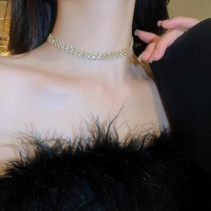 Close-up of sparkling gold choker necklace with dense rhinestone inlay on a model