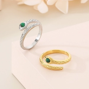 Detailed view of gold and silver snake rings with malachite inlay and scale texture