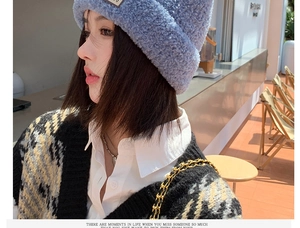 Close-up of light blue sherpa knit hat featuring a woven brand label and cozy texture