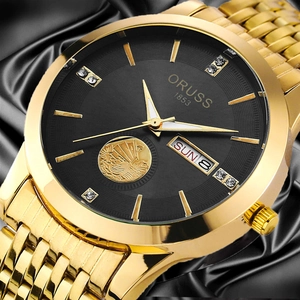 Macro detail of gold-plated watch dial with diamond markers and relief sailboat motif