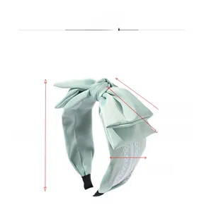 Detail of mint green bow headband featuring white lace lining and anti-slip tips